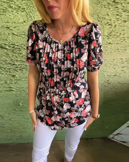 Blusa floreale plissettata con maniche a sbuffo e scollo tondo